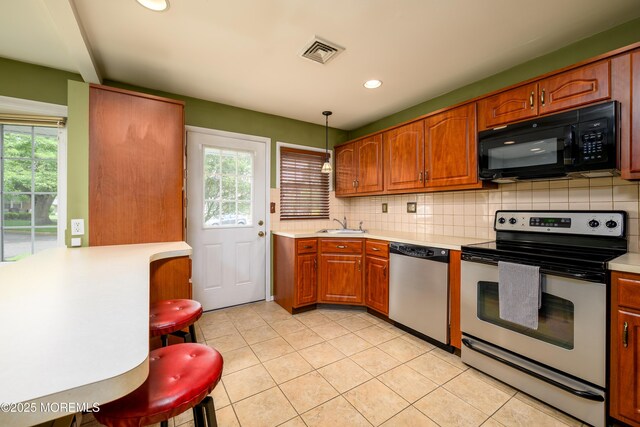 1161B Argyll Cir, Lakewood, NJ 08701 - kitchen with stainless steel appliances, plenty of natural light, light countertops, tasteful backsplash, and recessed lighting