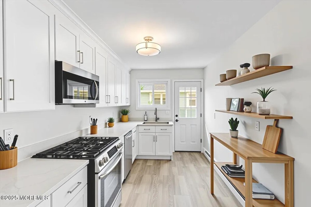 16 Mount Kisco Dr, Toms River, NJ 08753 - kitchen featuring appliances with stainless steel finishes, open shelves, white cabinetry, light wood-style flooring, and light stone countertops