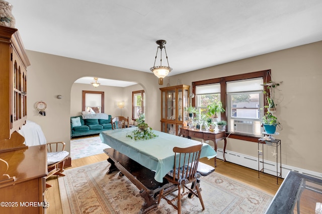 18 Slocum St, West Long Branch, NJ 07764 - dining space with arched walkways, a baseboard radiator, light wood-type flooring, and cooling unit