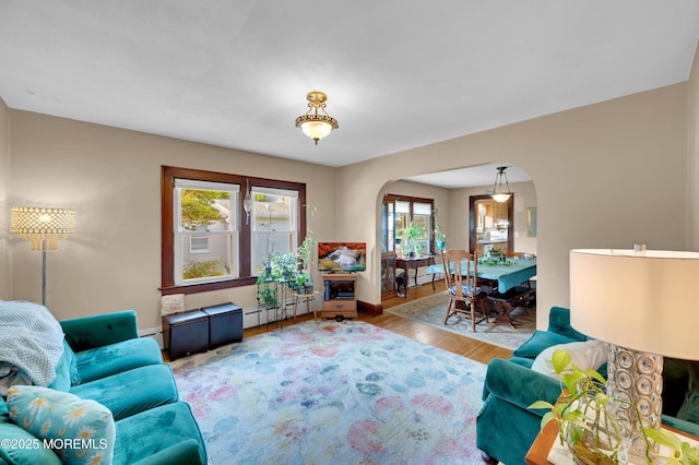 18 Slocum St, West Long Branch, NJ 07764 - living area featuring arched walkways, a baseboard radiator, and wood finished floors