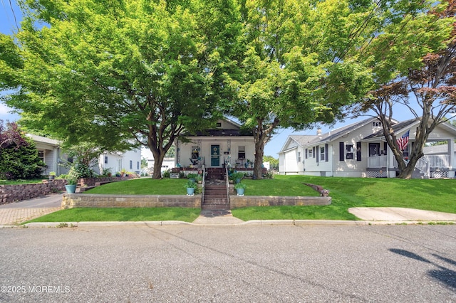 18 Slocum St, West Long Branch, NJ 07764 - view of front facade with covered porch, a front lawn, and a residential view