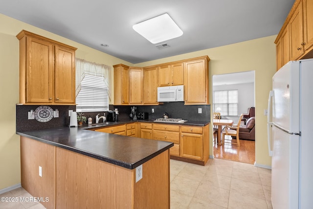 160 Kyle Ct Unit 160, Monroe, NJ 08831 - kitchen featuring white appliances, a peninsula, decorative backsplash, dark countertops, and light tile patterned flooring