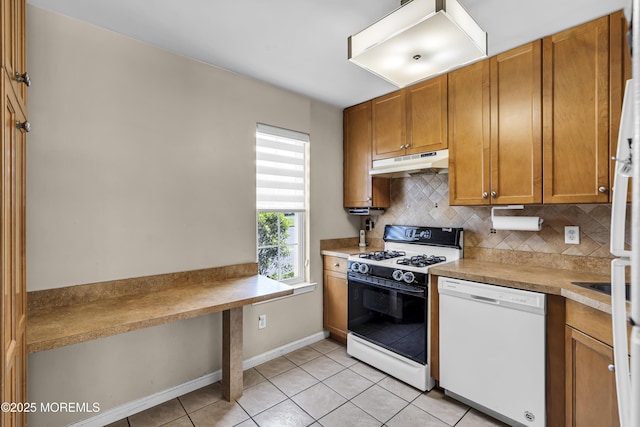 106 Aspen Ct, Lakewood, NJ 08701 - kitchen with white dishwasher, under cabinet range hood, range with gas cooktop, backsplash, and brown cabinetry