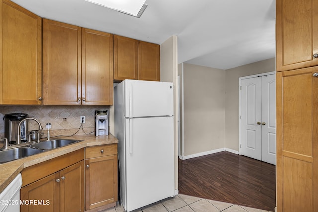 106 Aspen Ct, Lakewood, NJ 08701 - kitchen featuring white appliances, backsplash, brown cabinets, light tile patterned floors, and light countertops