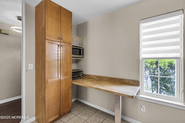 106 Aspen Ct, Lakewood, NJ 08701 - kitchen with brown cabinetry, light countertops, stainless steel microwave, and light tile patterned flooring