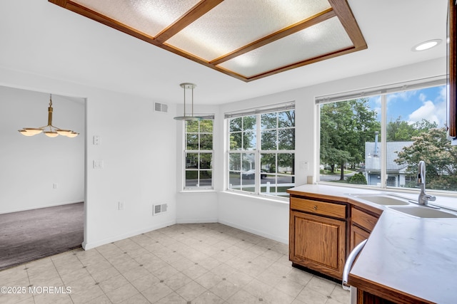 1091A Canterbury Dr, Manchester, NJ 08759 - kitchen with healthy amount of natural light, light countertops, decorative light fixtures, and brown cabinets