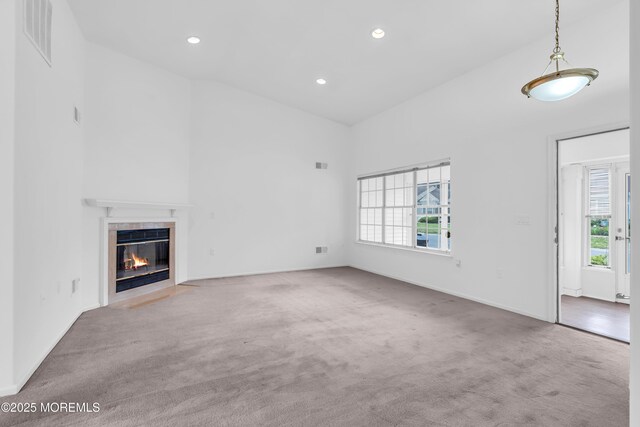 1091A Canterbury Dr, Manchester, NJ 08759 - unfurnished living room with carpet floors, a tiled fireplace, a high ceiling, and recessed lighting