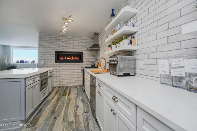 675 Ocean Ave Unit 5J, Long Branch, NJ 07740 - kitchen with brick wall, dark wood-type flooring, a brick fireplace, wall chimney exhaust hood, and gray cabinets
