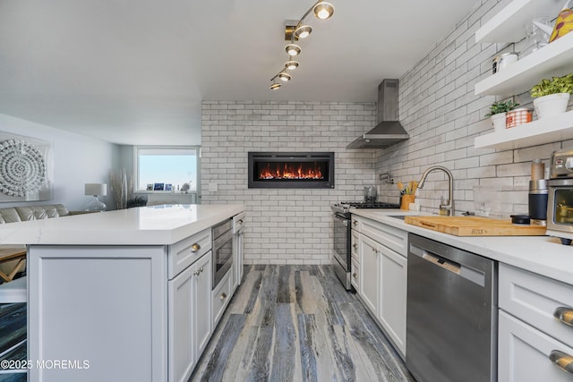 675 Ocean Ave Unit 5J, Long Branch, NJ 07740 - kitchen with stainless steel appliances, wall chimney exhaust hood, open floor plan, light countertops, and dark wood-style flooring