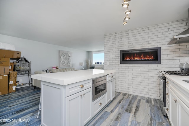 675 Ocean Ave Unit 5J, Long Branch, NJ 07740 - kitchen featuring appliances with stainless steel finishes, open floor plan, wood finished floors, white cabinetry, and light countertops