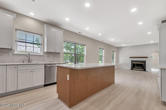 31 Orleans Dr, Manchester, NJ 08759 - kitchen with stainless steel dishwasher, a center island, light wood finished floors, light countertops, and healthy amount of natural light