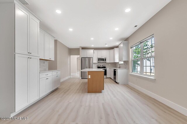 31 Orleans Dr, Manchester, NJ 08759 - kitchen with stainless steel appliances, light countertops, tasteful backsplash, a center island, and white cabinets