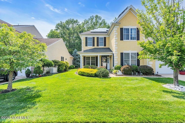 19 Carleton Dr, Freehold, NJ 07728 - view of front facade with a front yard, stucco siding, solar panels, and a garage