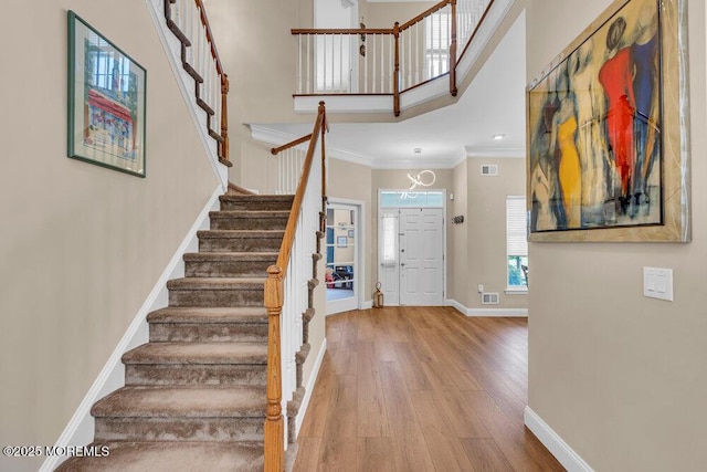 19 Carleton Dr, Freehold, NJ 07728 - stairway with ornamental molding, hardwood / wood-style flooring, and a towering ceiling