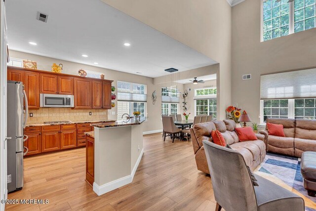 19 Carleton Dr, Freehold, NJ 07728 - kitchen featuring appliances with stainless steel finishes, open floor plan, brown cabinetry, light wood-style floors, and recessed lighting
