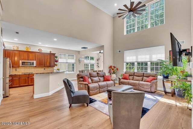 19 Carleton Dr, Freehold, NJ 07728 - living room with a ceiling fan, crown molding, light wood-style floors, a towering ceiling, and recessed lighting