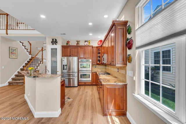 19 Carleton Dr, Freehold, NJ 07728 - kitchen featuring stainless steel appliances, brown cabinetry, light stone countertops, light wood-style floors, and recessed lighting