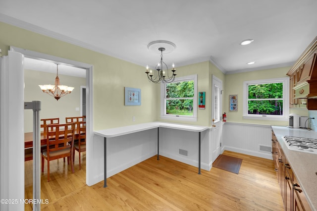 4607 Broad St, Wall, NJ 07753 - kitchen with a chandelier, light wood-style flooring, crown molding, light countertops, and decorative light fixtures