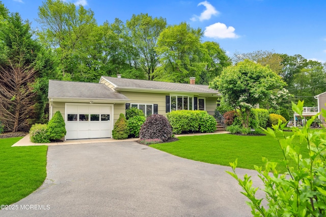 4607 Broad St, Wall, NJ 07753 - view of front facade with an attached garage, asphalt driveway, a front lawn, and a chimney