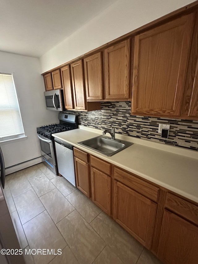 66 Fox Rd Unit 10A, Edison, NJ 08817 - kitchen with appliances with stainless steel finishes, a baseboard radiator, brown cabinetry, and backsplash
