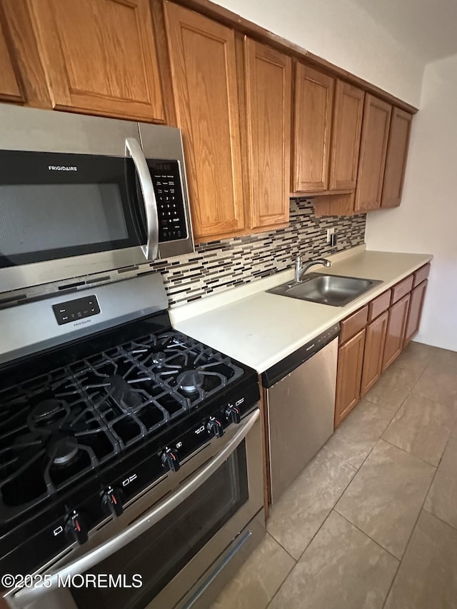 66 Fox Rd Unit 10A, Edison, NJ 08817 - kitchen with stainless steel appliances, tasteful backsplash, light countertops, and brown cabinetry