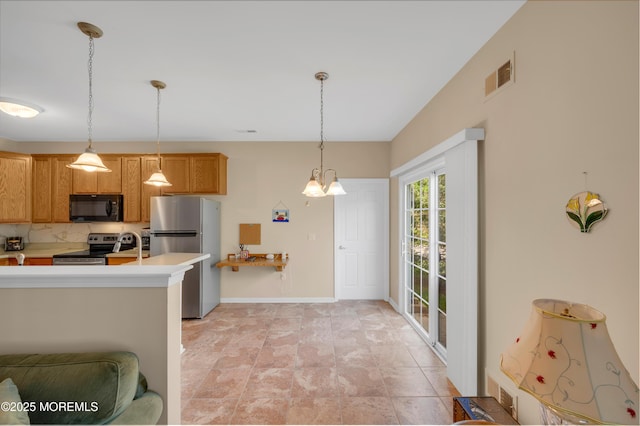 52 Country Walk Blvd, Whiting, NJ 08759 - kitchen featuring stainless steel appliances, light countertops, hanging light fixtures, tasteful backsplash, and brown cabinets