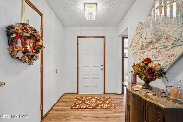 236 Community Cir, Old Bridge, NJ 08857 - doorway with light wood-type flooring and a textured ceiling