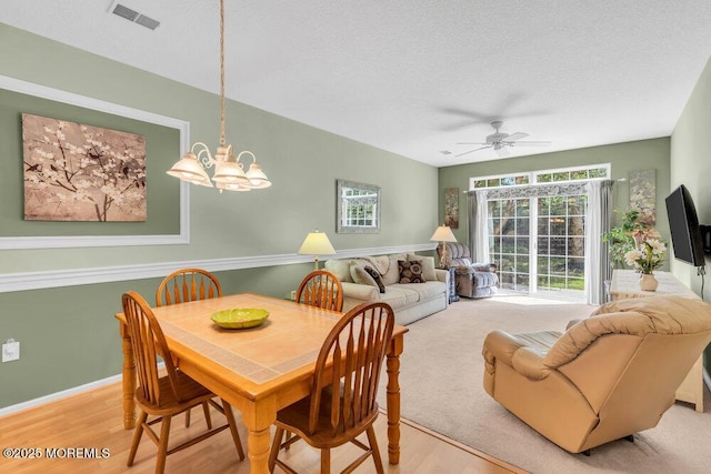 44 Autumntide Dr, Lakewood, NJ 08701 - dining space with light wood-style flooring, a chandelier, ceiling fan, and a textured ceiling