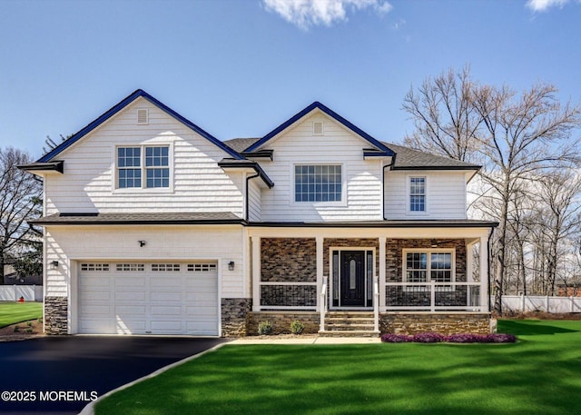 413B Lake Shr, Brick, NJ 08723 - view of front of house with stone siding, asphalt driveway, an attached garage, a front lawn, and a porch