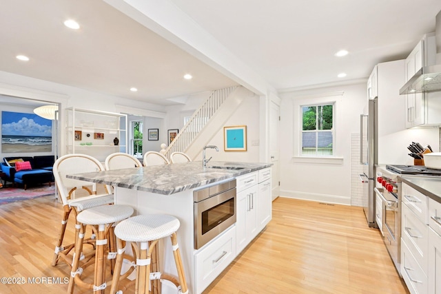 13031/2 Langford St, Asbury Park, NJ 07712 - kitchen featuring stainless steel appliances, a kitchen bar, light wood-style floors, white cabinetry, and recessed lighting