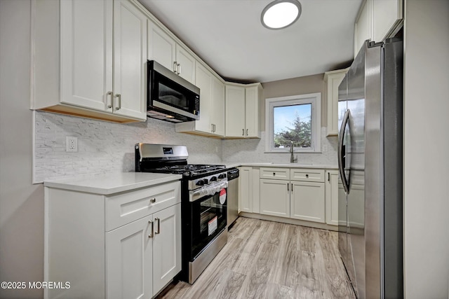 48 Sheepshead Dr, Toms River, NJ 08757 - kitchen featuring stainless steel appliances, light countertops, backsplash, light wood-style floors, and white cabinets