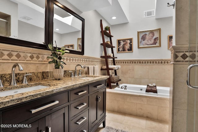 7 Navesink Ct, Long Branch, NJ 07740 - bathroom with double vanity, a garden tub, tile patterned flooring, a shower stall, and wainscoting