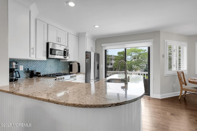 7 Navesink Ct, Long Branch, NJ 07740 - kitchen with stainless steel appliances, tasteful backsplash, light stone counters, wood-type flooring, and recessed lighting