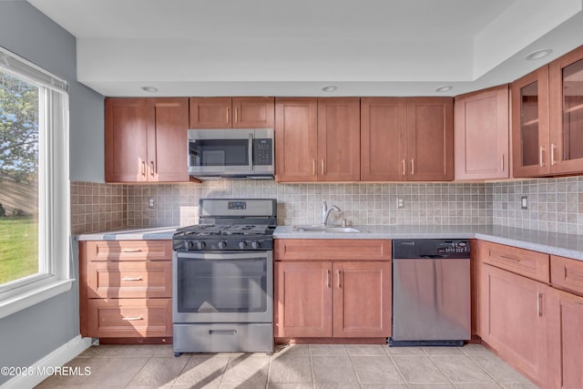 23 Arlene Ct Unit 4103, Brick, NJ 08723 - kitchen with appliances with stainless steel finishes, light countertops, tasteful backsplash, light tile patterned flooring, and brown cabinets