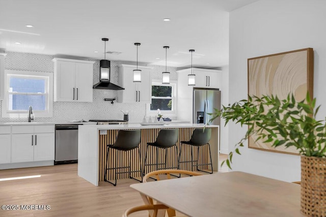 9 Westbrook Dr, Toms River, NJ 08757 - kitchen featuring wall chimney range hood, stainless steel appliances, backsplash, a center island, and white cabinetry