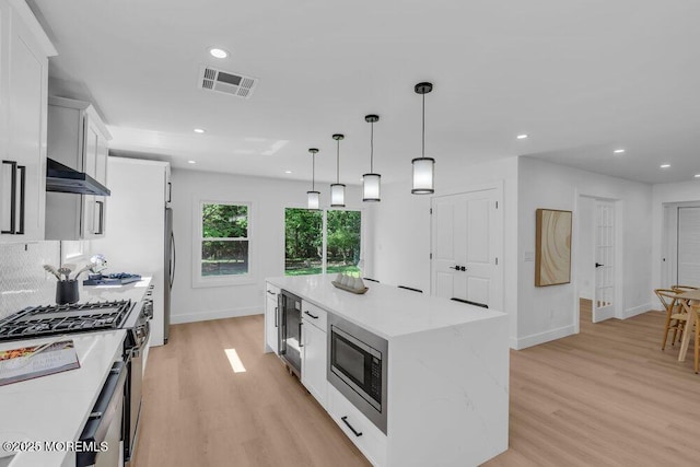 9 Westbrook Dr, Toms River, NJ 08757 - kitchen featuring appliances with stainless steel finishes, a kitchen island, light wood-style floors, white cabinetry, and recessed lighting