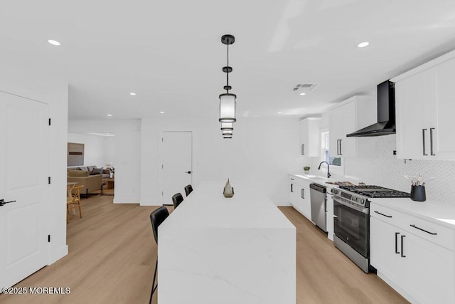 9 Westbrook Dr, Toms River, NJ 08757 - kitchen with wall chimney exhaust hood, stainless steel appliances, light wood-type flooring, backsplash, and recessed lighting