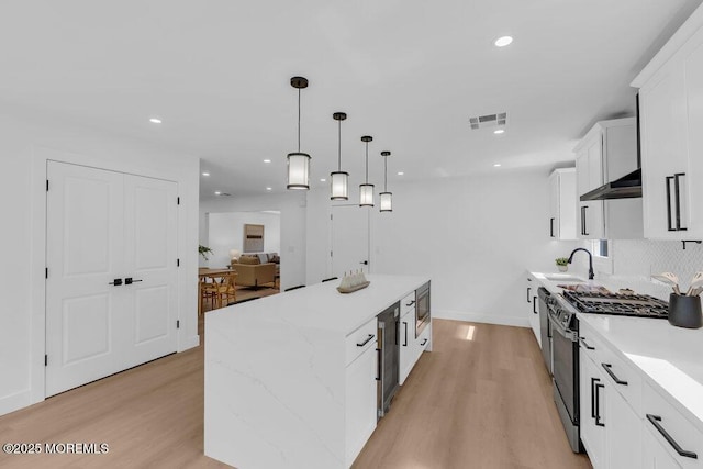9 Westbrook Dr, Toms River, NJ 08757 - kitchen featuring stainless steel appliances, a center island, light wood-style flooring, white cabinets, and hanging light fixtures