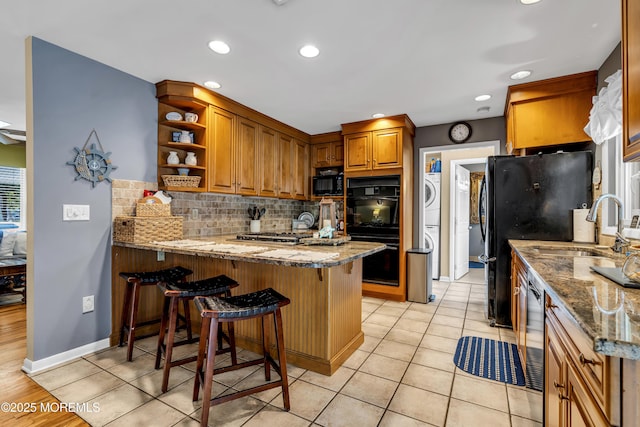 702 Saint Louis Ave, Point Pleasant Beach, NJ 08742 - kitchen featuring stacked washer / dryer, black appliances, a peninsula, backsplash, and open shelves