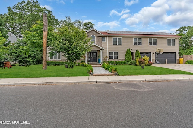 1159 County Line Rd E, Lakewood, NJ 08701 - view of front of property featuring solar panels, a garage, a front yard, and concrete driveway