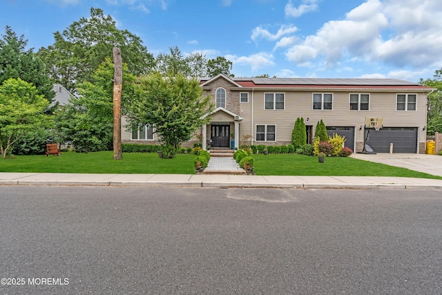 1159 County Line Rd E, Lakewood, NJ 08701 - view of front of property featuring an attached garage, roof mounted solar panels, a front lawn, and concrete driveway