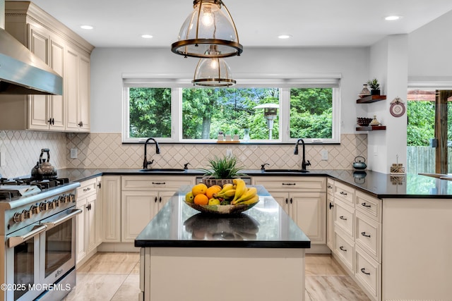 1159 County Line Rd E, Lakewood, NJ 08701 - kitchen with range with two ovens, wall chimney range hood, cream cabinets, plenty of natural light, and recessed lighting