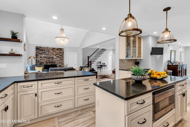 1159 County Line Rd E, Lakewood, NJ 08701 - kitchen featuring stainless steel microwave, dark countertops, open floor plan, a fireplace, and cream cabinets