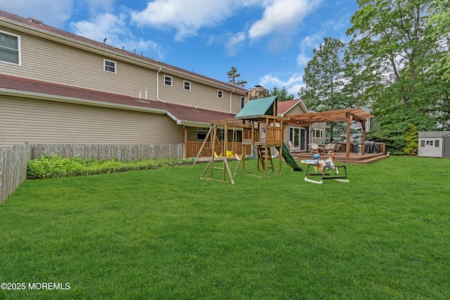 1159 County Line Rd E, Lakewood, NJ 08701 - rear view of property with a playground, a fenced backyard, a pergola, and a wooden deck