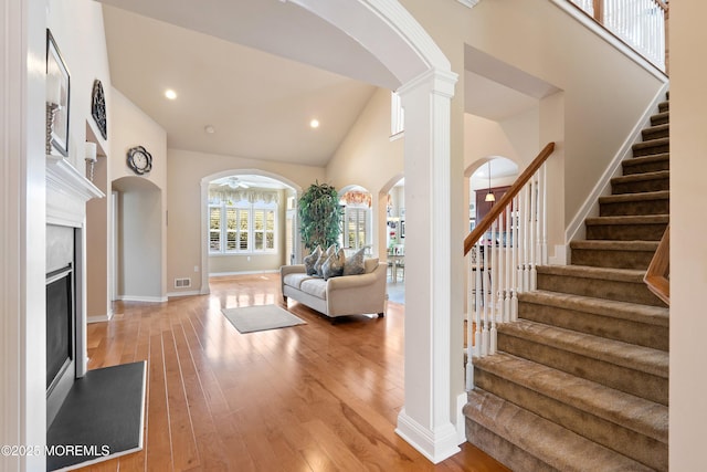 19 E Francesa Ct, Farmingdale, NJ 07727 - foyer with arched walkways, stairs, light wood-type flooring, a fireplace, and high vaulted ceiling