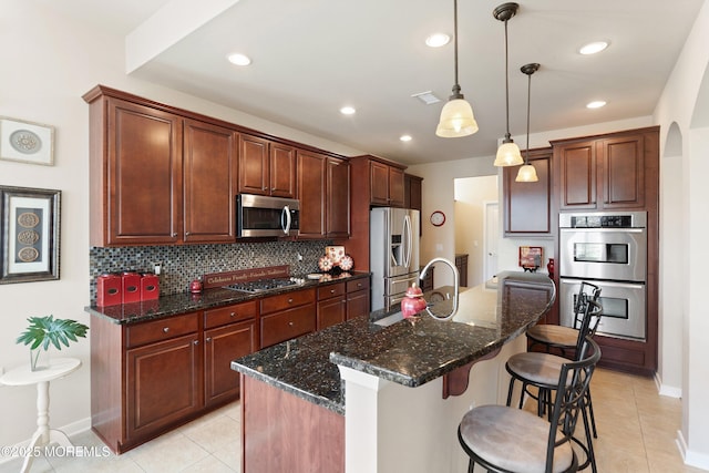 19 E Francesa Ct, Farmingdale, NJ 07727 - kitchen featuring appliances with stainless steel finishes, a kitchen bar, tasteful backsplash, light tile patterned flooring, and recessed lighting
