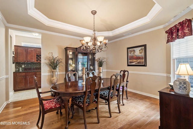 19 E Francesa Ct, Farmingdale, NJ 07727 - dining room with a tray ceiling, plenty of natural light, light wood-style floors, a chandelier, and crown molding