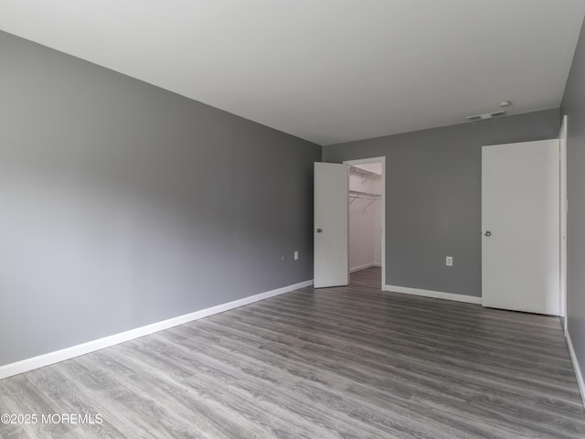 304 Wellington Pl, Aberdeen, NJ 07747 - unfurnished bedroom featuring wood finished floors, a closet, and a walk in closet