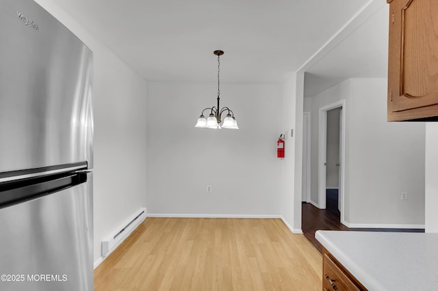 24 Ironside Dr Unit B, Whiting, NJ 08759 - unfurnished dining area featuring a baseboard radiator, light wood-type flooring, and a chandelier