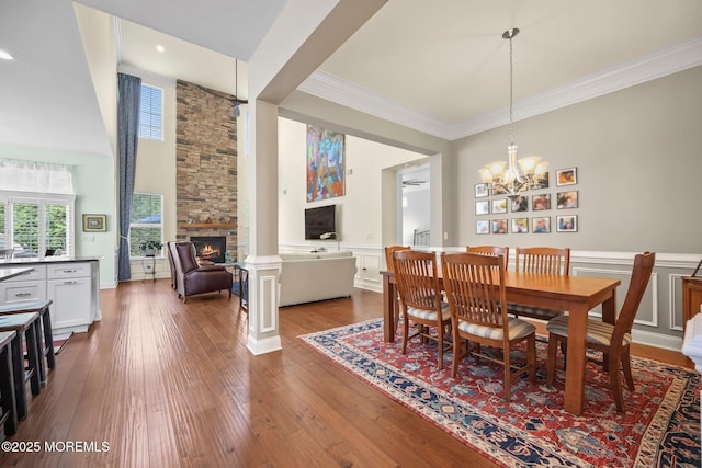 86 Legacy Ct, Freehold, NJ 07728 - dining space featuring a fireplace, dark wood finished floors, ornamental molding, wainscoting, and a chandelier